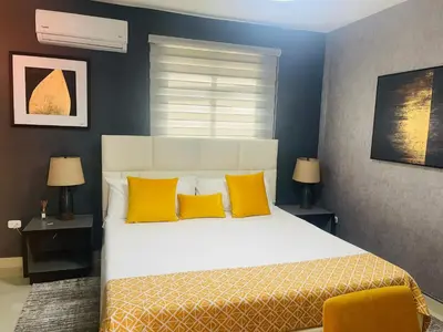 a bedroom with a large bed with yellow pillows at El Paso Hotel in Arroyo de Agua