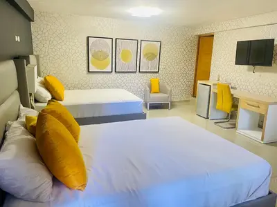 a hotel room with two beds with yellow pillows at El Paso Hotel in Arroyo de Agua