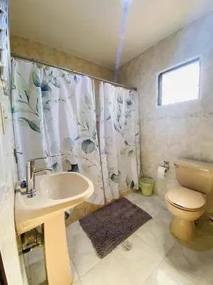 a bathroom with a sink and a toilet and a shower curtain at Villa Marcia in Boca Chica