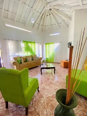 a living room with green chairs and a couch at Villa Marcia in Boca Chica