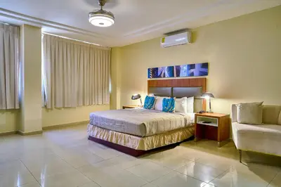a hotel room with a bed and a couch at Hotel Libertad at historic main street in Santo Domingo