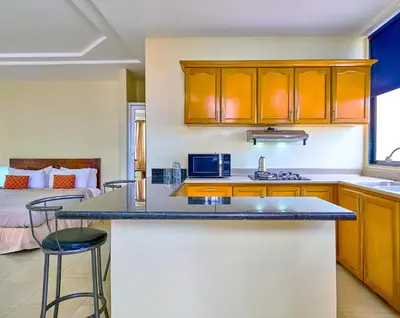 a kitchen with a counter and a bed in a room at Hotel Libertad at historic main street in Santo Domingo