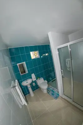 a bathroom with a toilet and a glass shower at D' Yoko Village's in Pedernales