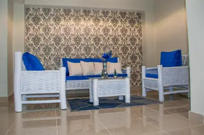 two white chairs and a table with blue pillows at D' Yoko Village's in Pedernales