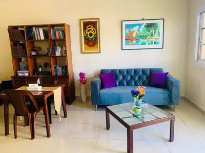 a living room with a blue couch and a table at Cerca del Mar, Obelisco Macho y Zona Colonial in Santo Domingo