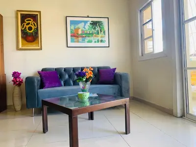 a living room with a blue couch and a table at Cerca del Mar, Obelisco Macho y Zona Colonial in Santo Domingo