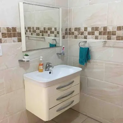 a white bathroom with a sink and a mirror at Cerca del Mar, Obelisco Macho y Zona Colonial in Santo Domingo