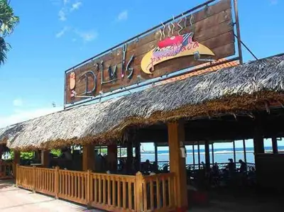 a restaurant with a straw roof and a sign at Cerca del Mar, Obelisco Macho y Zona Colonial in Santo Domingo