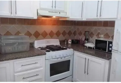 a kitchen with white cabinets and a stove top oven at Cerca del Mar, Obelisco Macho y Zona Colonial in Santo Domingo