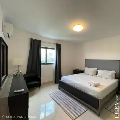 a bedroom with a bed and a chair at Soha panorama- A14- 2 dormitorios in Santiago de los Caballeros