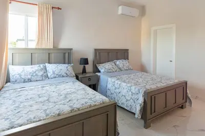 a bedroom with two beds and a window at The Green Palms 5 Bedroom villa with pool / garden in San Felipe de Puerto Plata