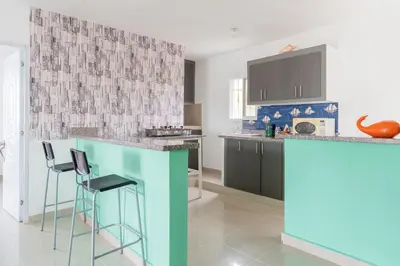 a kitchen with a blue counter and stools at Mi refugio cerca del aeropuerto in Santo Domingo