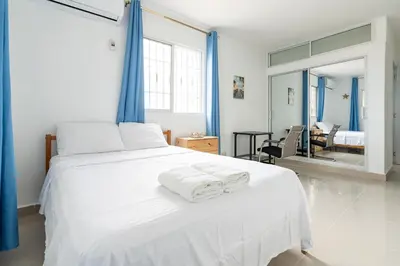 a bedroom with a white bed with towels on it at Mi refugio cerca del aeropuerto in Santo Domingo