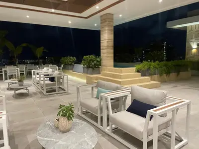a lobby with white chairs and a table and stairs at Piantini’s Skylight in Santo Domingo
