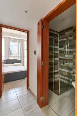 a bedroom with a bed and a glass walk in shower at N1001 Gran vista Downtown Santo Domingo RD in Santo Domingo