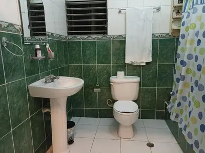 a green tiled bathroom with a toilet and a sink at La casa de Isabel y Juan, Zona Colonial in Santo Domingo