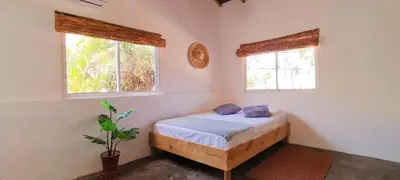 a bedroom with a bed and two windows at Kite House Cabarete across Kite Beach in Cabarete