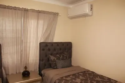 a bedroom with a bed and a air conditioner at Las Cayenas Residéncial in Santo Domingo
