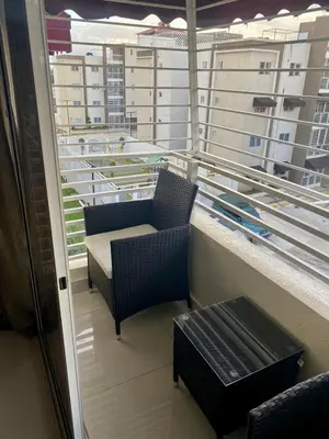 a balcony with two chairs and a table on a building at Apartamento Esme in Santo Domingo