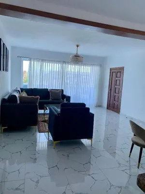 a living room with blue couches and a table at Madome Aparta Hotel in Pedernales