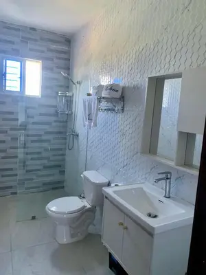 a white bathroom with a toilet and a sink at Madome Aparta Hotel in Pedernales