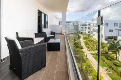 a balcony with chairs and tables on a building at Beachfront penthouse - Amar'e Aparthotel & Spa in Las Terrenas