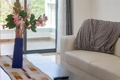 a living room with a chair and a vase with flowers at Beachfront penthouse - Amar'e Aparthotel & Spa in Las Terrenas