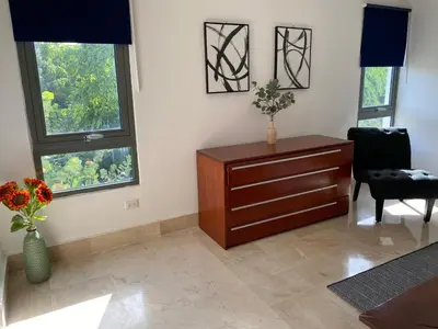 a living room with a dresser and two windows at Beachfront penthouse - Amar'e Aparthotel & Spa in Las Terrenas