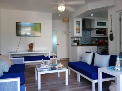 a living room with a blue couch and a table at Acceso Exclusivo A Club De Playa Totalmente Gratis, Areas Sociales Con BBQ, Piscina, Jacuzzi, Gazebos, Baños, Ducha Exterior, Wifi, Netflix Y Al Lado De Minimarkets, Restaurantes, Bares, Tiendas, Campos De Golf, Hoteles, Bancos Comerciales, Etc in Guayacanes