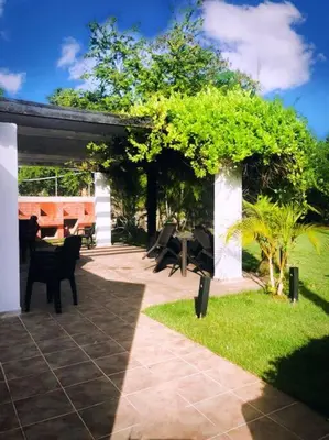 a patio with tables and chairs under a pavilion at Acceso Exclusivo A Club De Playa Totalmente Gratis, Areas Sociales Con BBQ, Piscina, Jacuzzi, Gazebos, Baños, Ducha Exterior, Wifi, Netflix Y Al Lado De Minimarkets, Restaurantes, Bares, Tiendas, Campos De Golf, Hoteles, Bancos Comerciales, Etc in Guayacanes