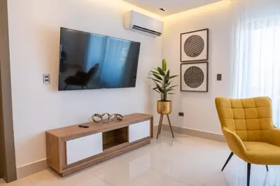 a living room with a flat screen tv on a wall at Top Floor in Luxury Tower in Santiago de los Caballeros