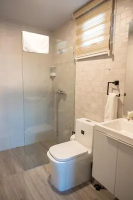 a bathroom with a toilet and a sink and a shower at Top Floor in Luxury Tower in Santiago de los Caballeros