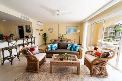 a living room with a couch and chairs and a table at Spacious Iberosta ApartmentSueno - 3BDR Pool, Beach, WiFi in Punta Cana