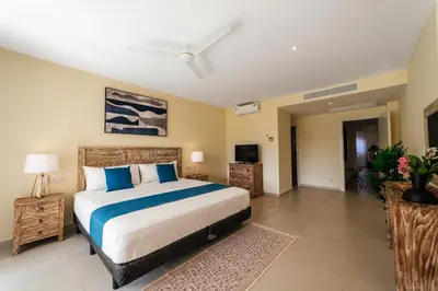 a bedroom with a large bed and a television at Spacious Iberosta ApartmentSueno - 3BDR Pool, Beach, WiFi in Punta Cana