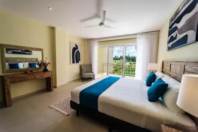 a bedroom with a large bed and a window at Spacious Iberosta ApartmentSueno - 3BDR Pool, Beach, WiFi in Punta Cana