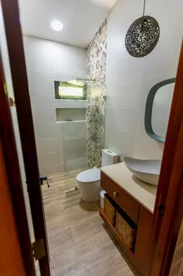 a bathroom with a toilet and a sink and a mirror at Beach Apartment Villas Jubey, Emotion access in Juan Dolio