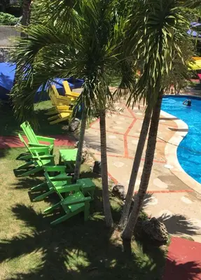two palm trees and lounge chairs next to a pool at Hacienda de Flores in Guayacanes