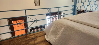 a bedroom with a bed and a blue railing at Colonial apartment for up to 4 person in Santo Domingo