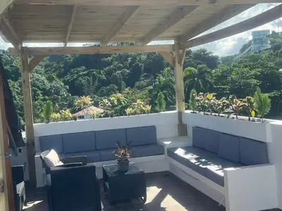 a porch with a bench and a view of a mountain at Armonia De Las Terrenas Gorgeous Penthouse in Las Terrenas
