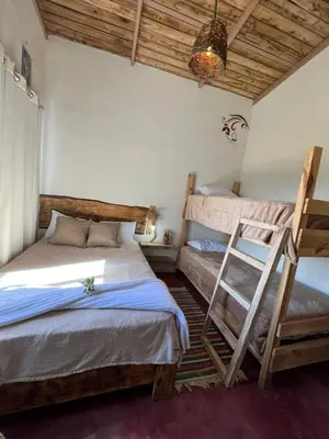 a bedroom with two bunk beds and a ladder at La Casita de Charo 1, disfruta de tiempo memorable en la montaña in Constanza