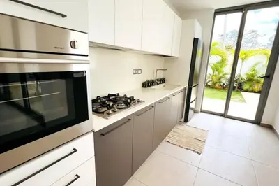 a kitchen with white cabinets and a stove top oven at 3 Bedroom Pool Villa 50M To The Beach in Las Terrenas