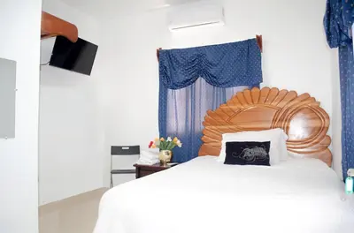 a bedroom with a large bed with a wooden headboard at Hotel las Nina in Paraíso