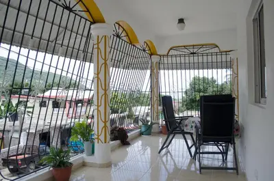 a room with two chairs and large windows at Hotel las Nina in Paraíso