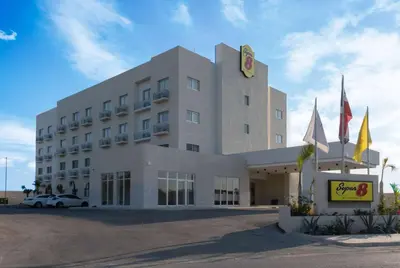 a large white building with a sign in front of it at Super 8 by Wyndham Manzanillo in Pepillo Salcedo