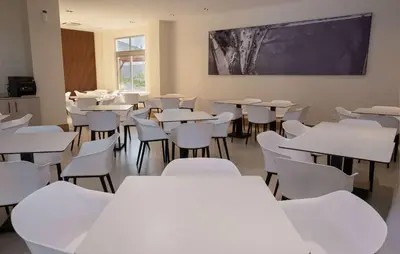 a classroom with white tables and chairs and a chalkboard at Super 8 by Wyndham Manzanillo in Pepillo Salcedo
