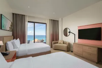 a hotel room with a bed and a flat screen tv at Hilton Garden Inn La Romana in La Romana