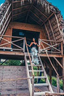 a woman standing on the stairs of a tree house at Samana Ecolodge in El Limón