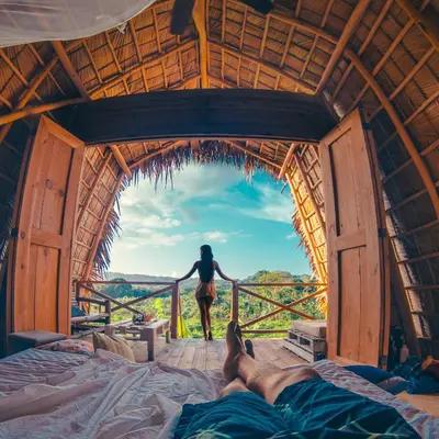 a woman standing on a balcony in a room with a view at Samana Ecolodge in El Limón
