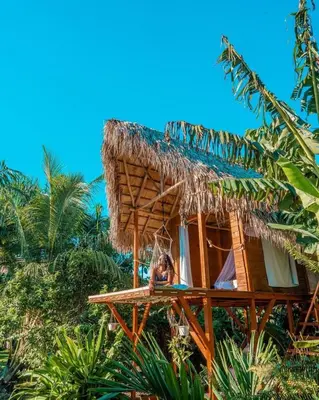 a woman is sitting in a tree house at Samana Ecolodge in El Limón