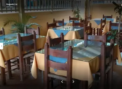 a group of tables and chairs in a restaurant at Habitación Hogareña in Jarabacoa